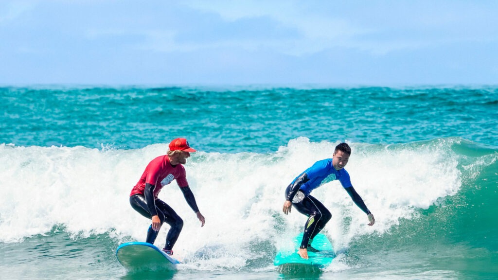 Surf instructor and a student learning how to surf.