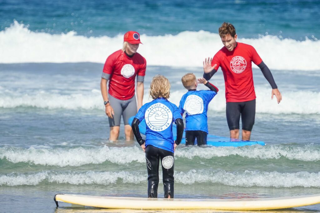 Surf coaches from Pacific Surf teaching two kids how to surf.