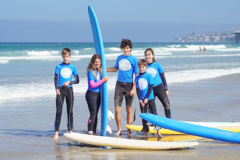 Children on the beach ready for group surf lessons in San Diego.