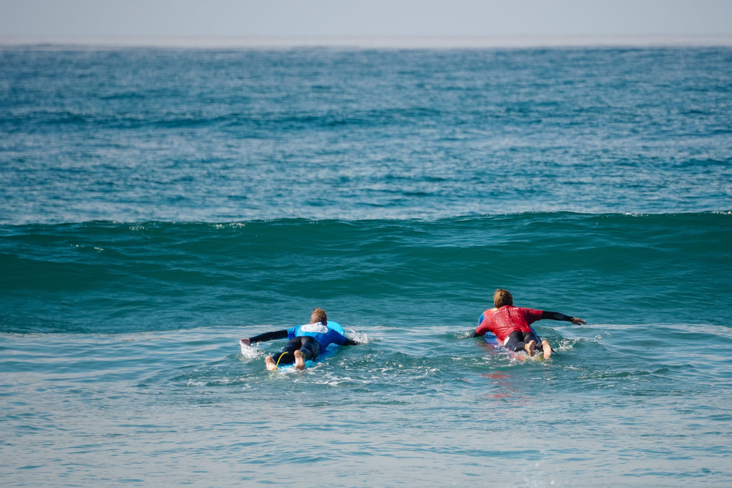 Surf instructor teaching a student how to drop in on a wave.