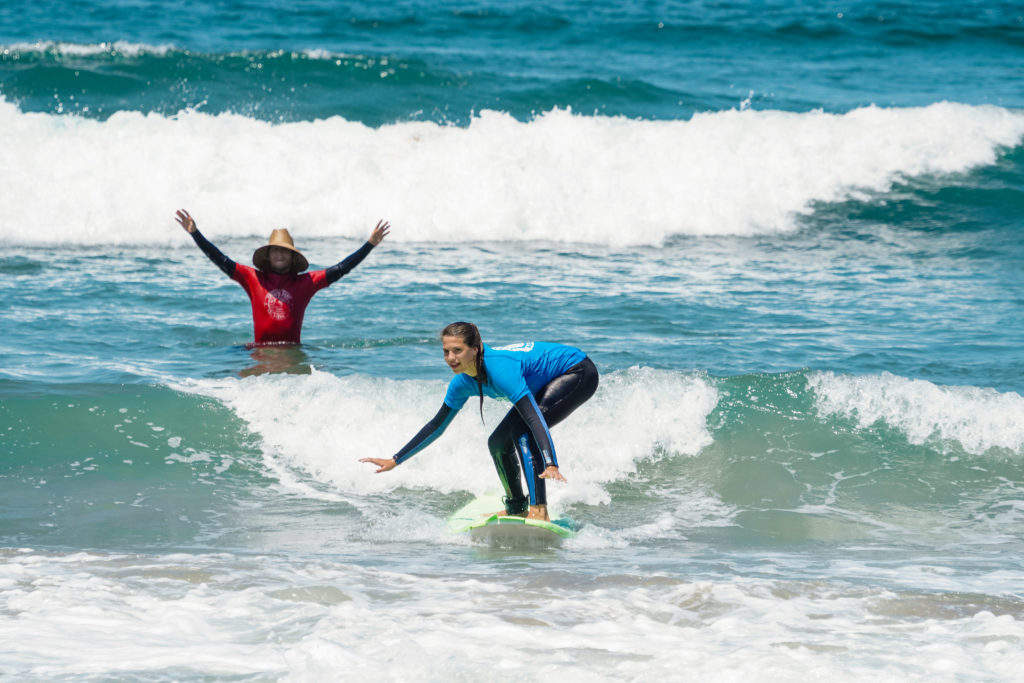 Surf instructor teaching a young student how to surf 