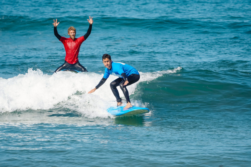Surf instructor teaching student how to catch more waves