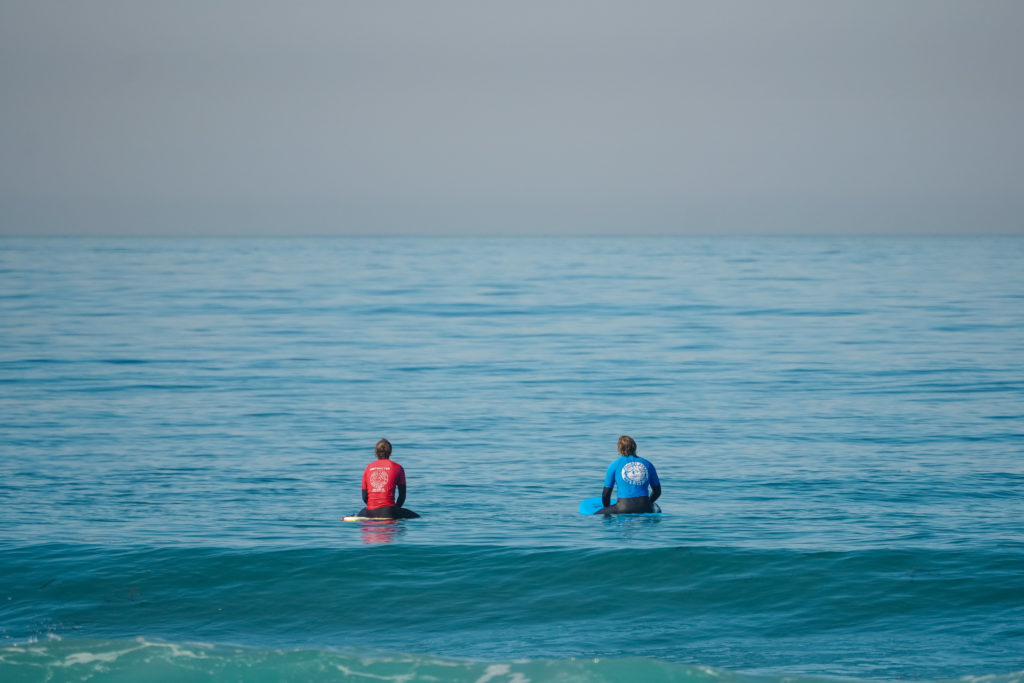 Surf instructor and student out on the water getting ready to surf