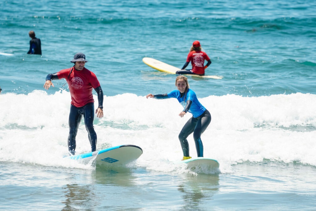 Surf instructor teaching a student how to surf.