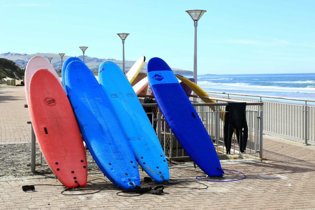 Soft top surfboards stacked against a railing