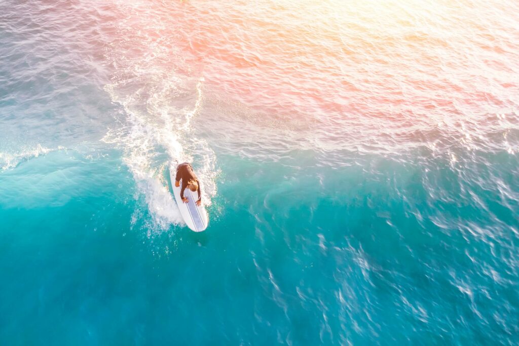 Aerial view of a surfer dropping in on a wave.