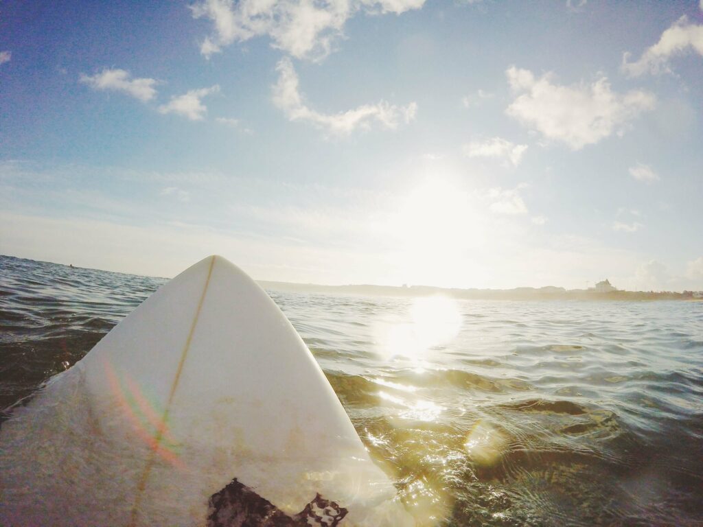 First-person view of a person laying down on a surfboard in the ocean