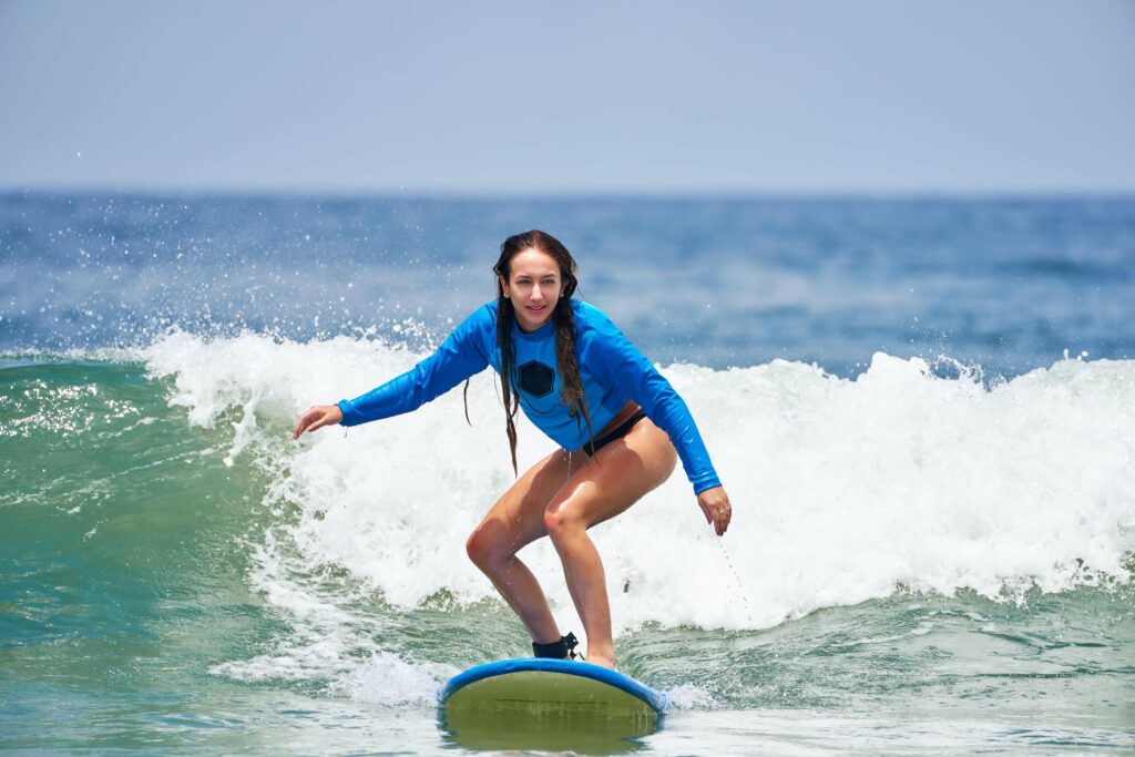 Young woman learning how to surf safely on the water.
