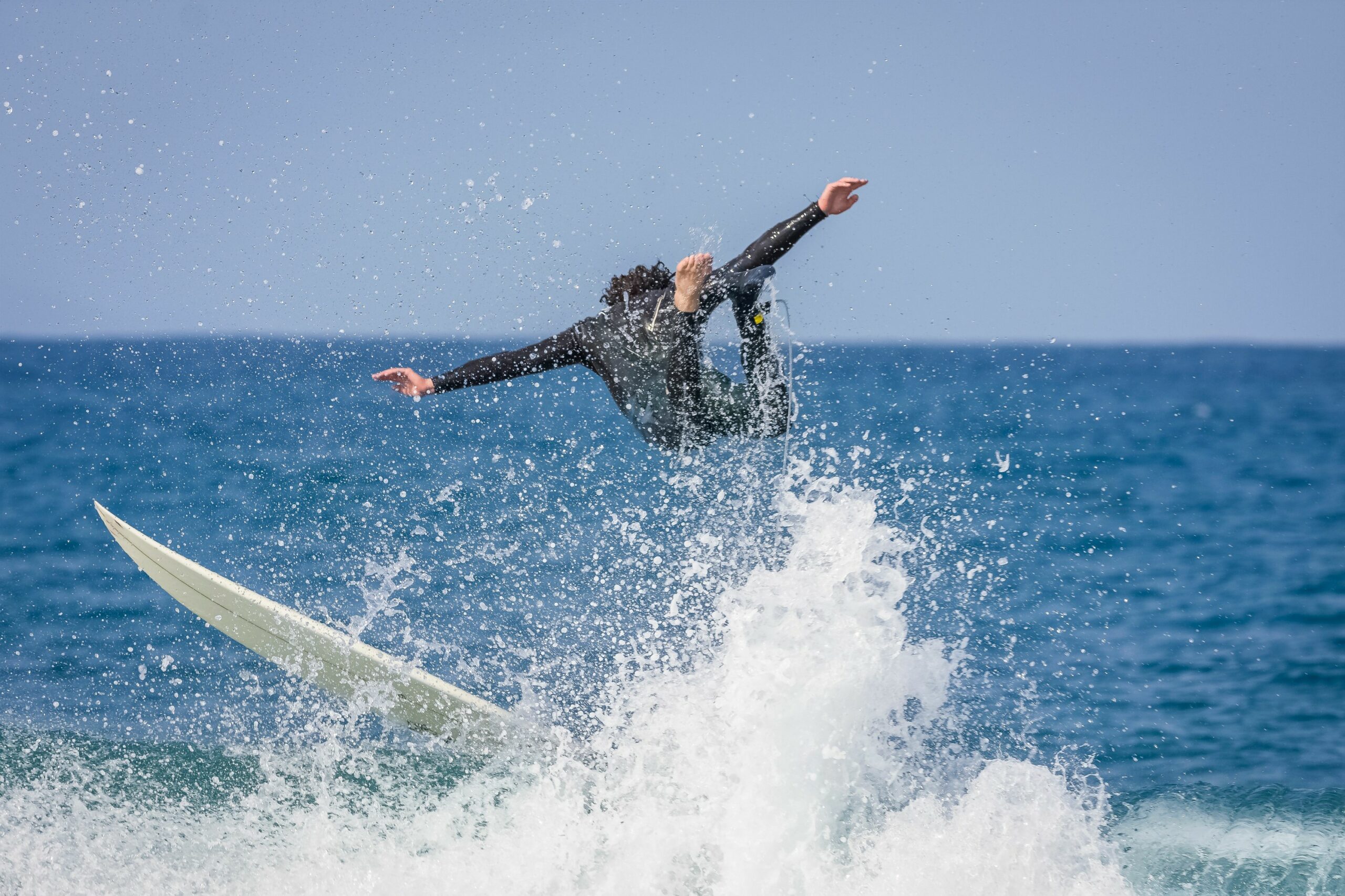 Surfer in wet suit riding board during wipeout.
