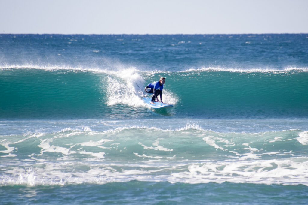 Student surfing a wave in a private surf lesson.